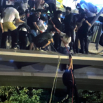 Protestors use a rope to lower themselves from a pedestrian bridge to waiting motorbikes in order to escape from Hong Kong Polytechnic University