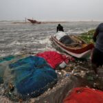 Fishermen move a fishing boat to a safer place along the shore before Cyclone Nivar's landfall, in Chennai, India, November 25, 2020.